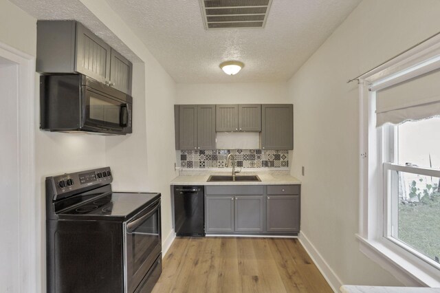 115 N Walnut St, Baltimore, OH 43105 - kitchen featuring black appliances, a sink, light wood-style flooring, gray cabinetry, and decorative backsplash