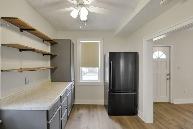 115 N Walnut St, Baltimore, OH 43105 - kitchen featuring freestanding refrigerator, gray cabinets, light wood-style flooring, a ceiling fan, and a textured ceiling