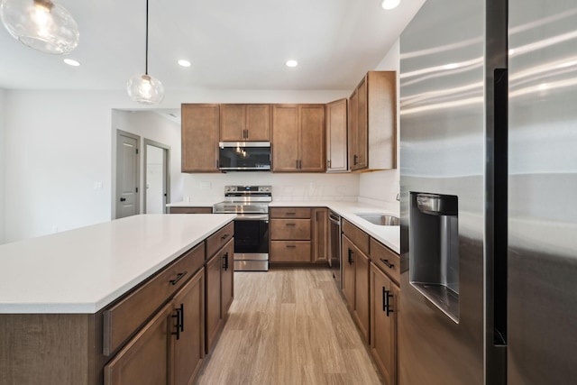 63 Hayden Ave, Columbus, OH 43222 - kitchen with appliances with stainless steel finishes, light wood-type flooring, recessed lighting, light countertops, and pendant lighting