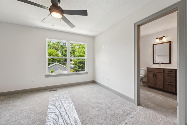 63 Hayden Ave, Columbus, OH 43222 - unfurnished bedroom with light carpet, connected bathroom, a ceiling fan, and a textured ceiling