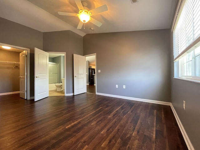 2001 Berrancher Dr, Columbus, OH 43228 - unfurnished bedroom featuring vaulted ceiling, baseboards, dark wood-style flooring, a walk in closet, and ensuite bathroom