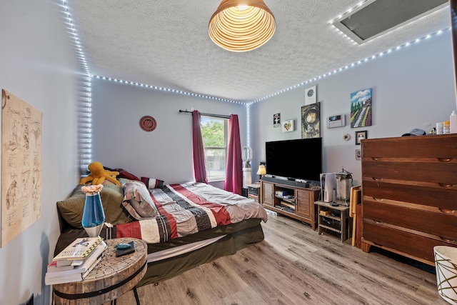 993 Esther Dr, Columbus, OH 43207 - bedroom with a textured ceiling, attic access, and wood finished floors