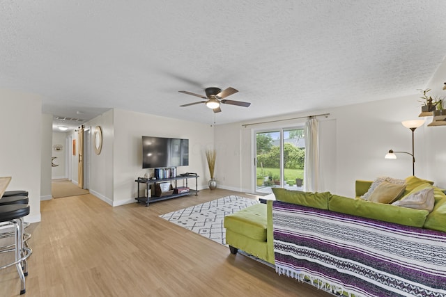 6576 Creon Dr, Reynoldsburg, OH 43068 - living room with wood finished floors, a textured ceiling, ceiling fan, and baseboards
