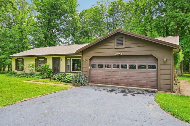 6769 Thoreau Ln NE, Baltimore, OH 43105 - single story home with asphalt driveway, an attached garage, metal roof, and a front lawn