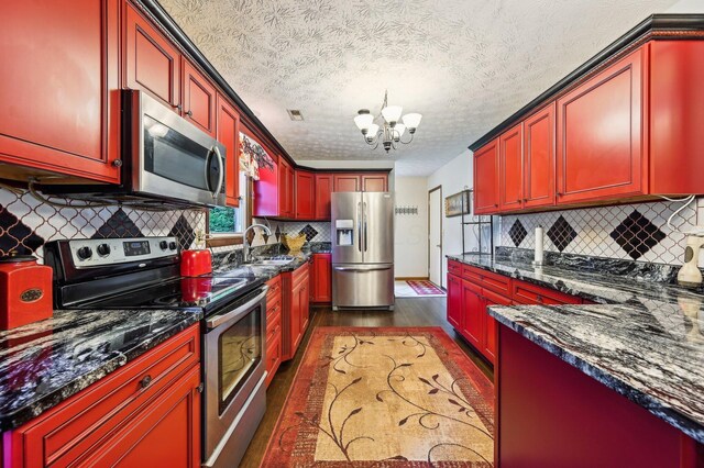 6769 Thoreau Ln NE, Baltimore, OH 43105 - kitchen with appliances with stainless steel finishes, dark wood-type flooring, a sink, reddish brown cabinets, and a chandelier