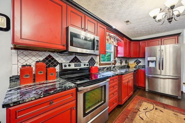6769 Thoreau Ln NE, Baltimore, OH 43105 - kitchen with appliances with stainless steel finishes, dark wood-style floors, a sink, a chandelier, and a textured ceiling