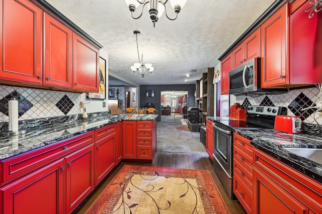 6769 Thoreau Ln NE, Baltimore, OH 43105 - kitchen featuring appliances with stainless steel finishes, a chandelier, dark wood finished floors, a textured ceiling, and decorative backsplash
