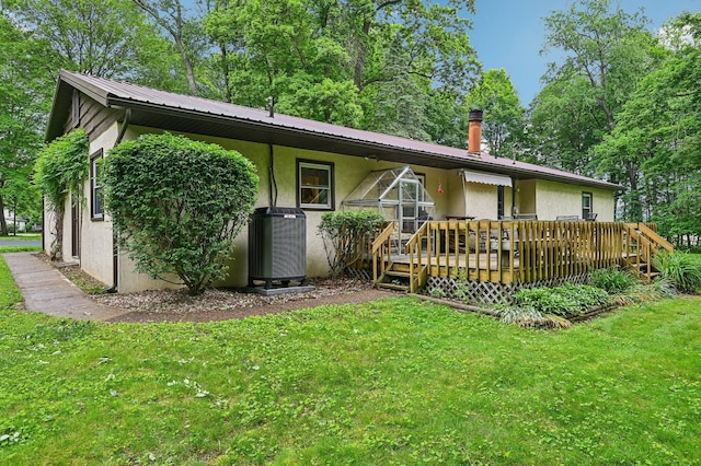 6769 Thoreau Ln NE, Baltimore, OH 43105 - back of property with stucco siding, a lawn, central air condition unit, and a wooden deck