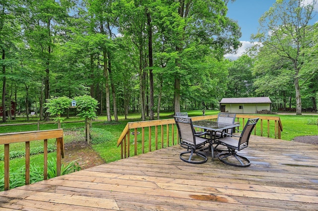 6769 Thoreau Ln NE, Baltimore, OH 43105 - wooden deck with outdoor dining space, a lawn, and an outbuilding