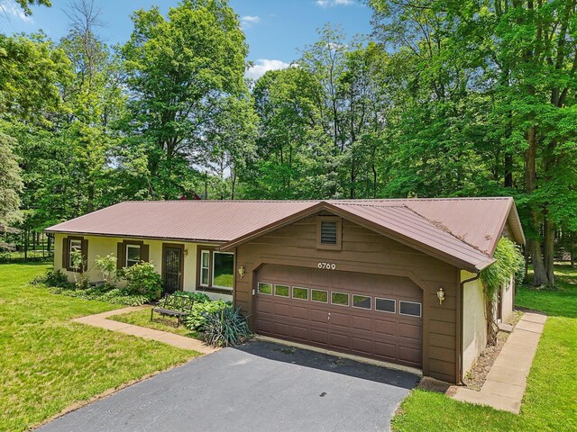 6769 Thoreau Ln NE, Baltimore, OH 43105 - single story home with asphalt driveway, an attached garage, a front yard, and metal roof