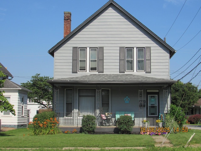 603 N Court St, Circleville, OH 43113 - view of front facade with a porch, a front lawn, a chimney, and roof with shingles
