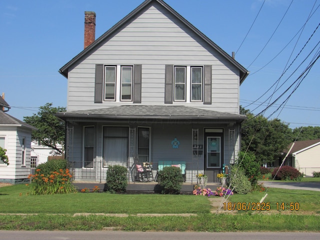 603 N Court St, Circleville, OH 43113 - view of front facade with a porch, a front yard, a chimney, and a shingled roof
