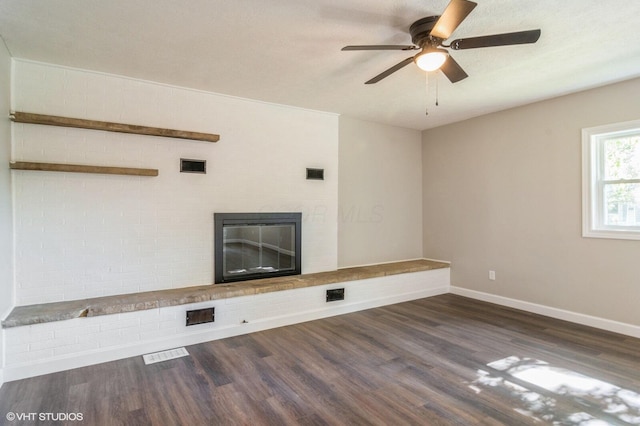 823 S Walnut St, Bucyrus, OH 44820 - unfurnished living room featuring wood finished floors, a brick fireplace, baseboards, and ceiling fan