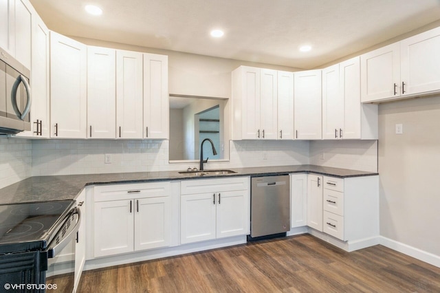 823 S Walnut St, Bucyrus, OH 44820 - kitchen featuring stainless steel appliances, a sink, dark wood-style floors, baseboards, and backsplash