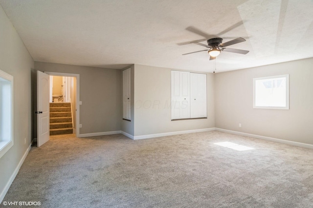 823 S Walnut St, Bucyrus, OH 44820 - unfurnished room with a ceiling fan, light carpet, baseboards, and stairway