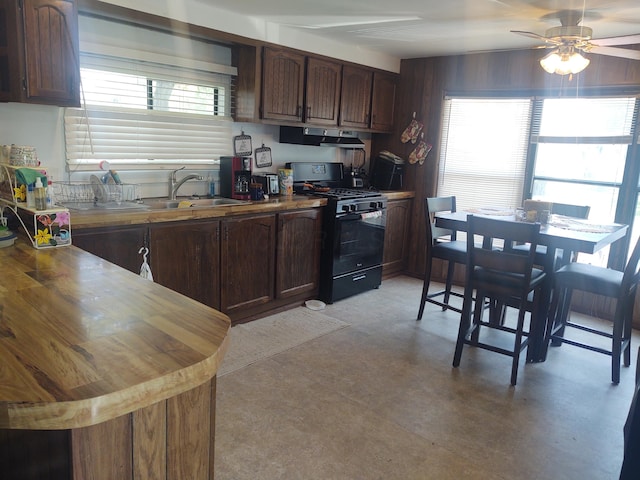 71 Knollwood Ct, South Bloomfield, OH 43103 - kitchen featuring gas stove, under cabinet range hood, concrete flooring, a ceiling fan, and dark brown cabinetry