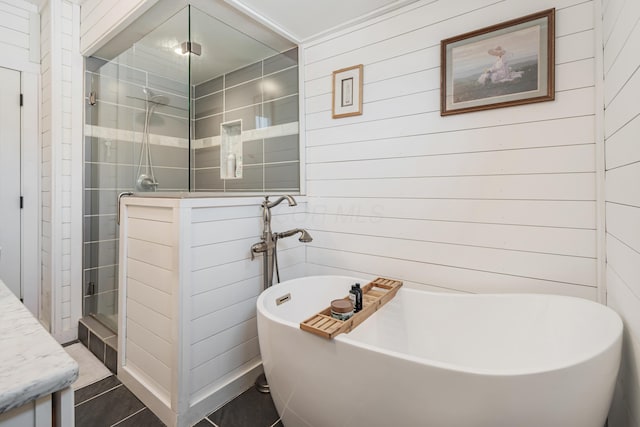 610 Chestnut St, Dresden, OH 43821 - bathroom featuring a stall shower, a freestanding tub, wooden walls, tile patterned flooring, and vanity