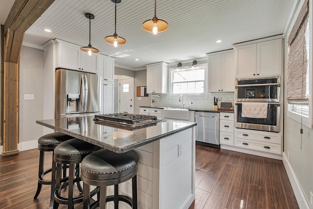 610 Chestnut St, Dresden, OH 43821 - kitchen with appliances with stainless steel finishes, decorative backsplash, a center island, a breakfast bar, and crown molding