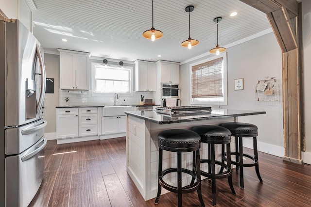 610 Chestnut St, Dresden, OH 43821 - kitchen featuring stainless steel appliances, a breakfast bar area, backsplash, dark wood-type flooring, and white cabinetry