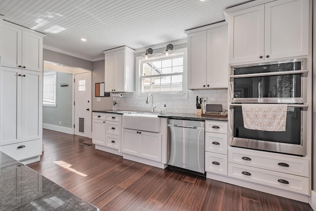 610 Chestnut St, Dresden, OH 43821 - kitchen featuring appliances with stainless steel finishes, white cabinets, dark wood-style floors, dark stone counters, and decorative backsplash