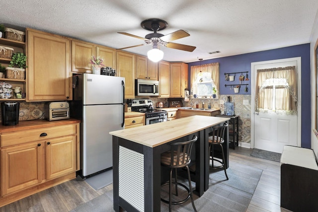 6769 Hildreth Ave, Columbus, OH 43229 - kitchen featuring appliances with stainless steel finishes, butcher block countertops, open shelves, a ceiling fan, and a textured ceiling