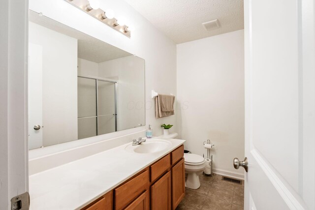 1420 Bellow Falls Pl, Columbus, OH 43228 - full bath with toilet, vanity, an enclosed shower, a textured ceiling, and tile patterned floors