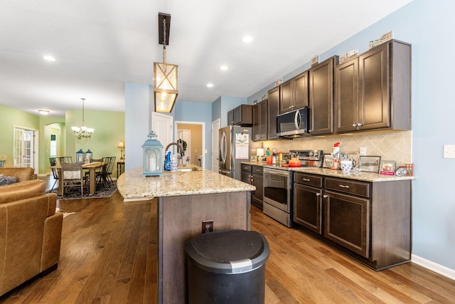 3736 Sanctuary, Hilliard, OH 43026 - kitchen featuring stainless steel appliances, a chandelier, open floor plan, dark brown cabinets, and recessed lighting