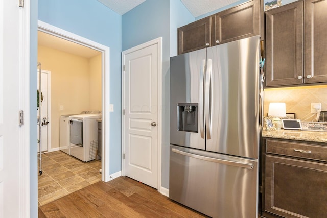 3736 Sanctuary, Hilliard, OH 43026 - kitchen featuring stainless steel refrigerator with ice dispenser, washing machine and clothes dryer, dark brown cabinetry, backsplash, and wood finished floors