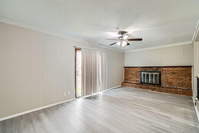 5359 Ivywood Ln, Columbus, OH 43229 - unfurnished living room with wood finished floors, ceiling fan, a textured ceiling, and a brick fireplace