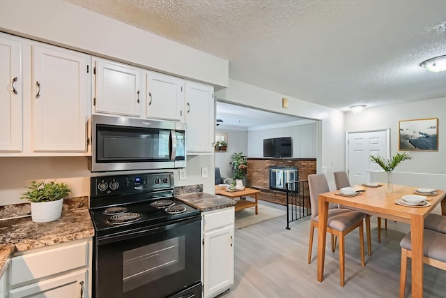 5359 Ivywood Ln, Columbus, OH 43229 - kitchen featuring stainless steel microwave, electric range, white cabinetry, a textured ceiling, and light wood finished floors