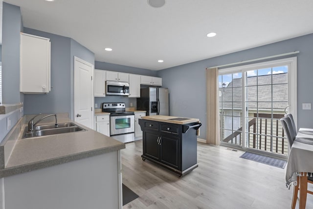 6310 Wagtail Rd Unit 6, Columbus, OH 43230 - kitchen with stainless steel appliances, a sink, white cabinets, light wood-style flooring, and dark cabinetry