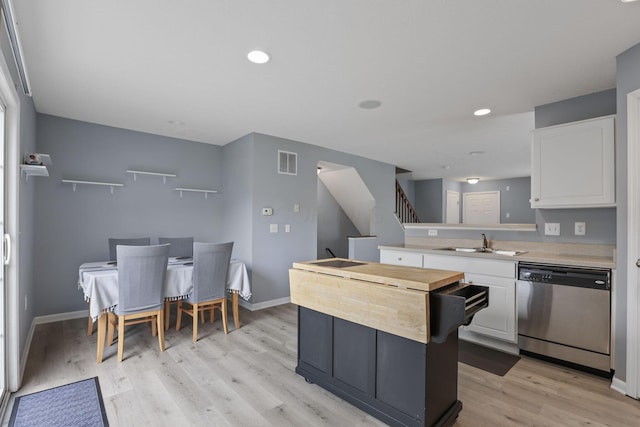 6310 Wagtail Rd Unit 6, Columbus, OH 43230 - kitchen featuring stainless steel dishwasher, a sink, white cabinetry, light wood-style floors, and a peninsula