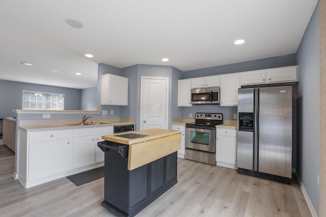 6310 Wagtail Rd Unit 6, Columbus, OH 43230 - kitchen featuring appliances with stainless steel finishes, a sink, white cabinetry, light wood-style floors, and recessed lighting
