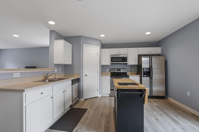 6310 Wagtail Rd Unit 6, Columbus, OH 43230 - kitchen featuring appliances with stainless steel finishes, a sink, a center island, light wood finished floors, and recessed lighting