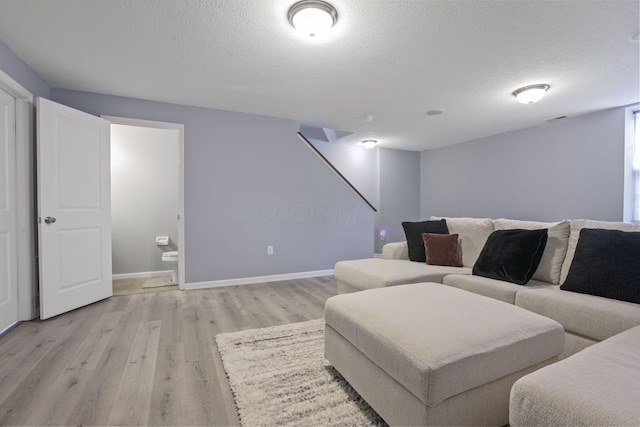 6310 Wagtail Rd Unit 6, Columbus, OH 43230 - living room with a textured ceiling, light wood finished floors, baseboards, and stairway