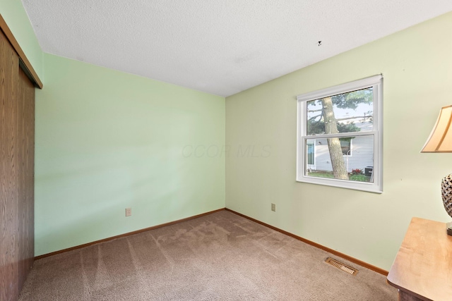 797 Timber Way Dr Unit 16C, Columbus, OH 43085 - unfurnished bedroom with carpet floors, a closet, baseboards, and a textured ceiling