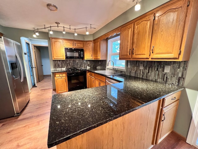 20600 Hellwig Rd, Utica, OH 43080 - kitchen featuring black appliances, a sink, light wood-style flooring, a peninsula, and dark stone countertops