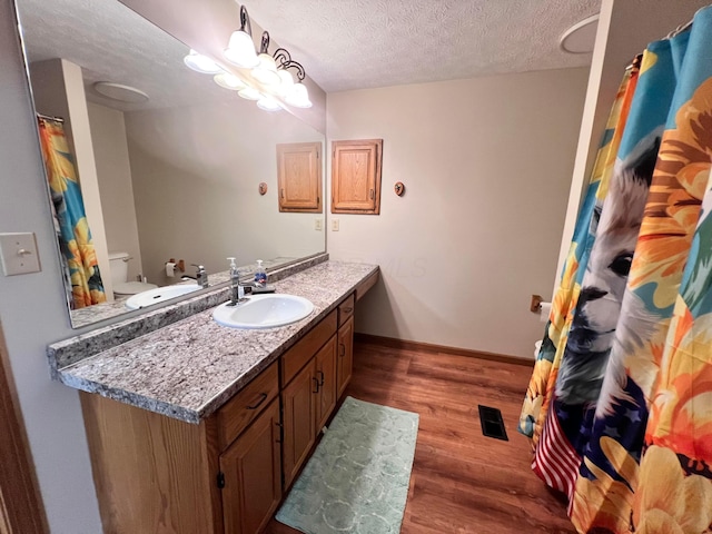 20600 Hellwig Rd, Utica, OH 43080 - bathroom with wood finished floors, a textured ceiling, vanity, toilet, and baseboards