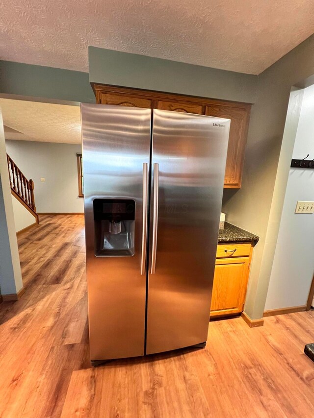 20600 Hellwig Rd, Utica, OH 43080 - kitchen featuring stainless steel fridge with ice dispenser, a textured ceiling, light wood-style floors, and baseboards