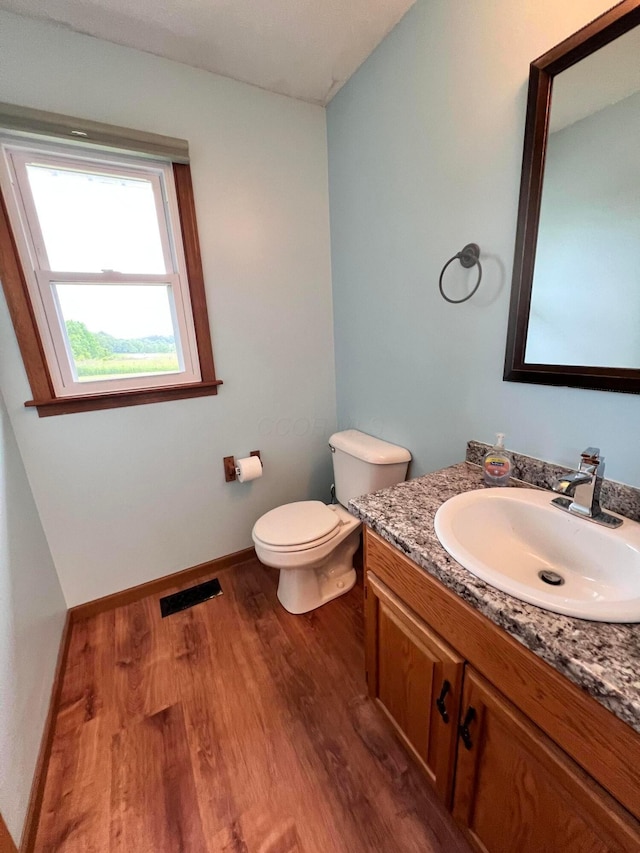 20600 Hellwig Rd, Utica, OH 43080 - bathroom featuring wood finished floors, toilet, vanity, and baseboards