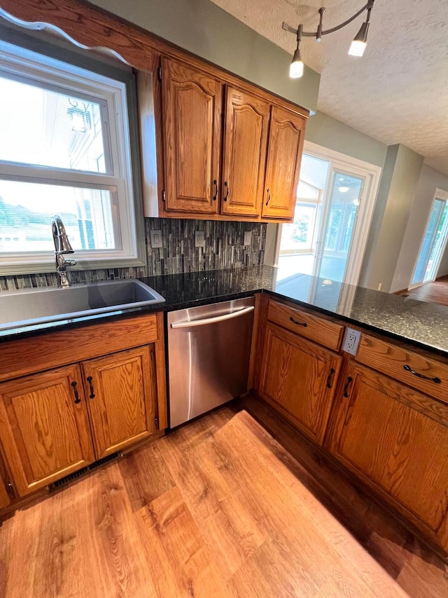 20600 Hellwig Rd, Utica, OH 43080 - kitchen featuring stainless steel dishwasher, a sink, brown cabinets, light wood-style floors, and healthy amount of natural light