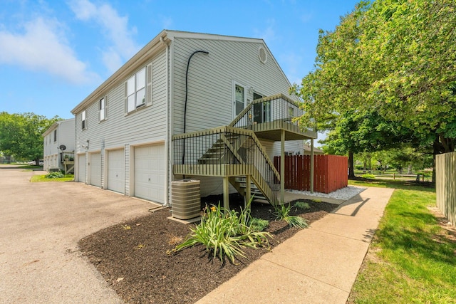3013 La Vista Dr Unit 29, Columbus, OH 43204 - view of property exterior featuring stairs, central air condition unit, asphalt driveway, an attached garage, and a wooden deck