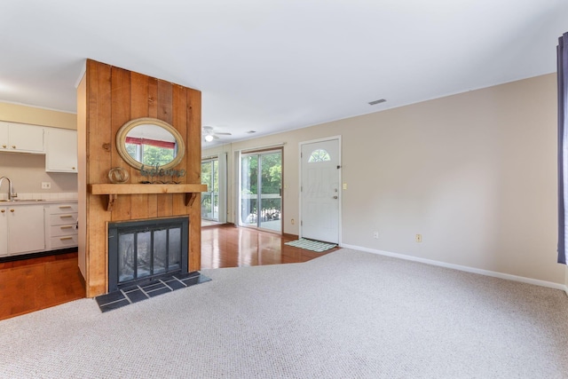 3013 La Vista Dr Unit 29, Columbus, OH 43204 - unfurnished living room with carpet flooring, a large fireplace, baseboards, a sink, and a ceiling fan