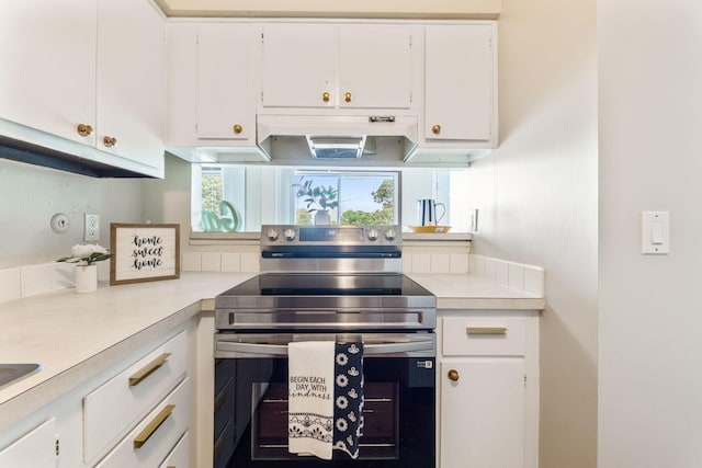3013 La Vista Dr Unit 29, Columbus, OH 43204 - kitchen with stainless steel electric stove, light countertops, white cabinets, and under cabinet range hood