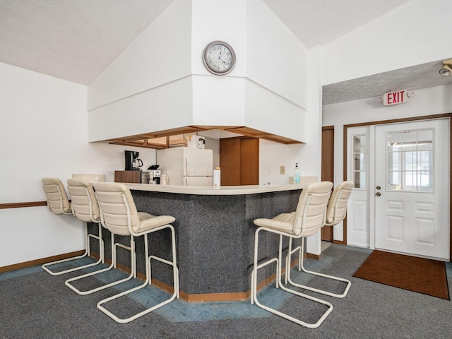 4393 Hammerton Dr Unit 14B, Columbus, OH 43228 - kitchen featuring freestanding refrigerator, carpet floors, high vaulted ceiling, and a breakfast bar