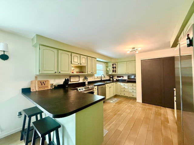 1855 Itawamba Trl, London, OH 43140 - kitchen with a sink, a peninsula, a kitchen breakfast bar, dark countertops, and stainless steel appliances