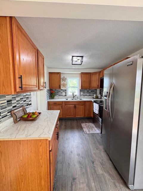 1729 E 17th Ave, Columbus, OH 43219 - kitchen featuring stainless steel fridge with ice dispenser, brown cabinets, dark wood finished floors, and a sink