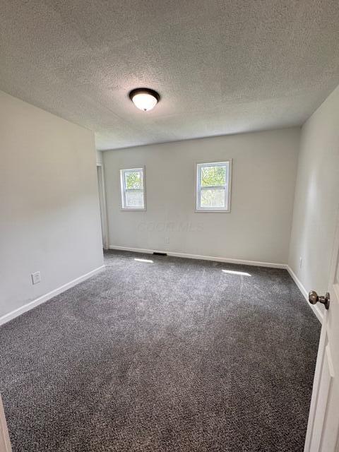 1729 E 17th Ave, Columbus, OH 43219 - carpeted spare room featuring baseboards and a textured ceiling