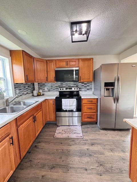 1729 E 17th Ave, Columbus, OH 43219 - kitchen with appliances with stainless steel finishes, a sink, dark wood-style floors, light countertops, and a textured ceiling