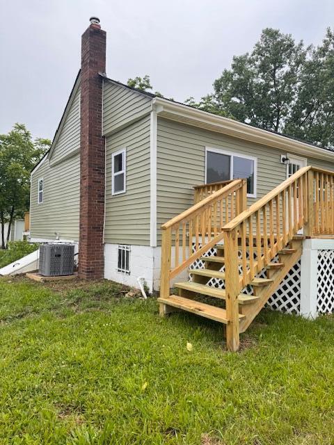 1729 E 17th Ave, Columbus, OH 43219 - rear view of house featuring a lawn, a chimney, stairs, and cooling unit